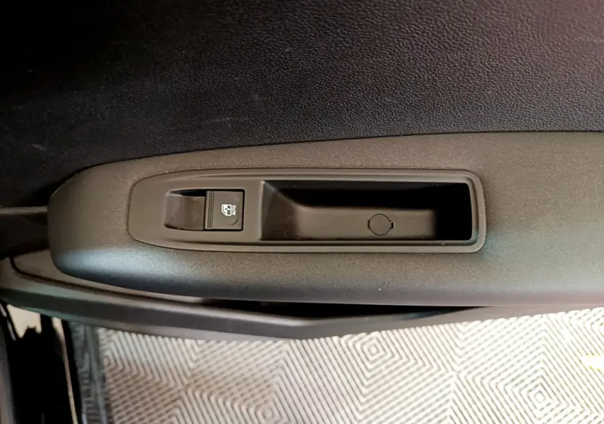 Détail de la commande de lève-vitre côté conducteur sur la porte intérieure noire d'un Renault Captur 2020 Business Blue dCi.