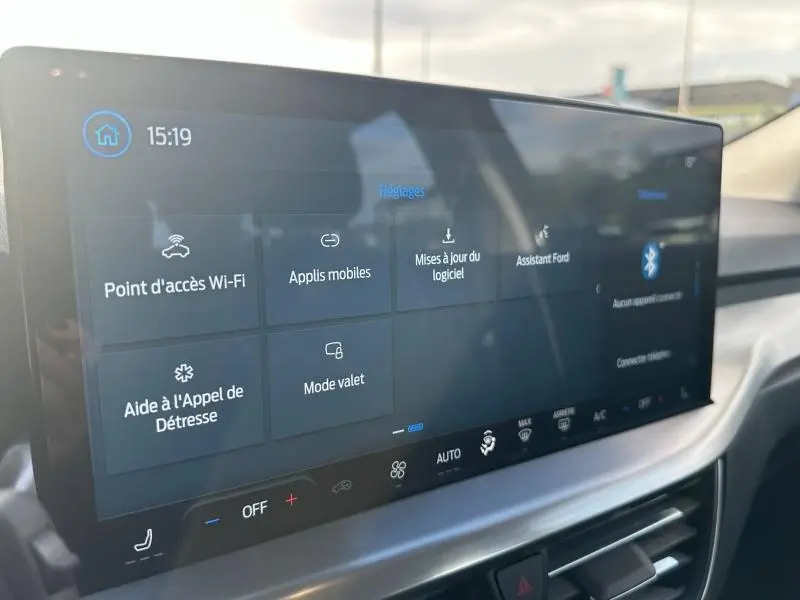 Écran tactile central de la Ford Focus 2023 noir Agate, affichant les réglages connectivité et assistance à 15h19
