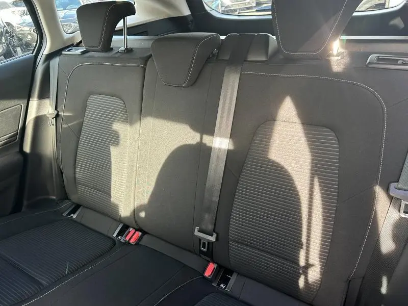 Vue intérieure arrière des sièges noirs de la Ford Focus 2023, avec appuie-têtes et ceinture de sécurité centrale visible.