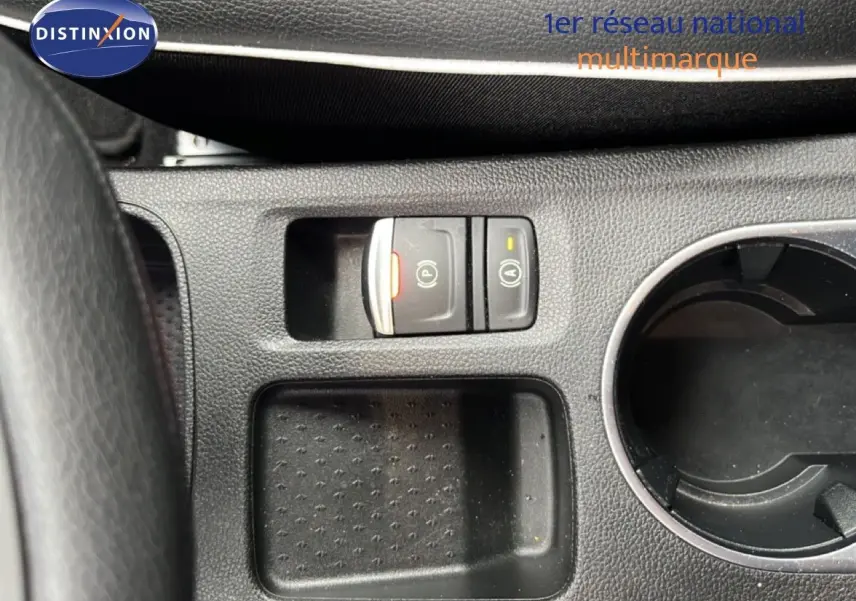 Gros plan sur la console centrale du Renault Captur 2021, montrant les boutons de frein à main électrique et arrêt/marche auto.