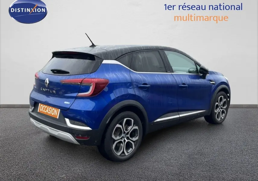Vue 3/4 arrière droite d'un Renault Captur bleu Iron Metal avec toit noir, roues alliage et feux LED distinctifs.