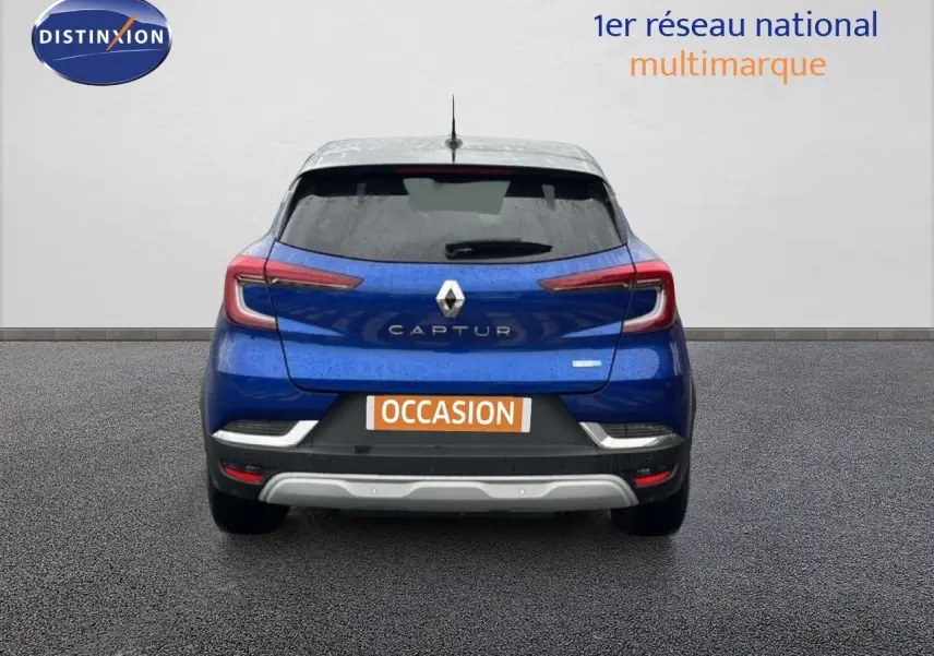 Vue arrière du Renault Captur 1.6 E-TECH bleu Iron Metal avec toit noir, mettant en valeur ses feux LED et son logo central.