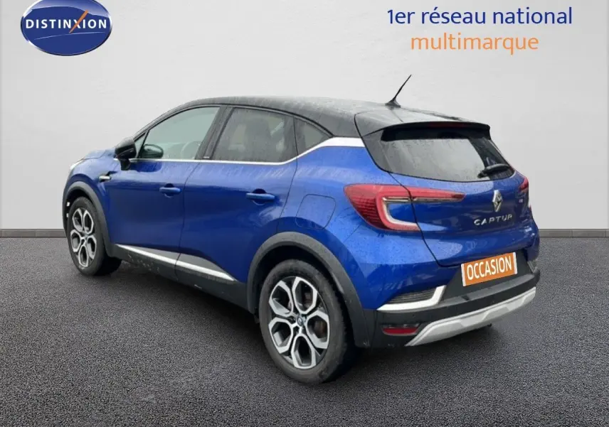 Vue 3/4 arrière droite d’un Renault Captur bleu Iron Metal avec toit noir, roues alliage et feux LED distinctifs.