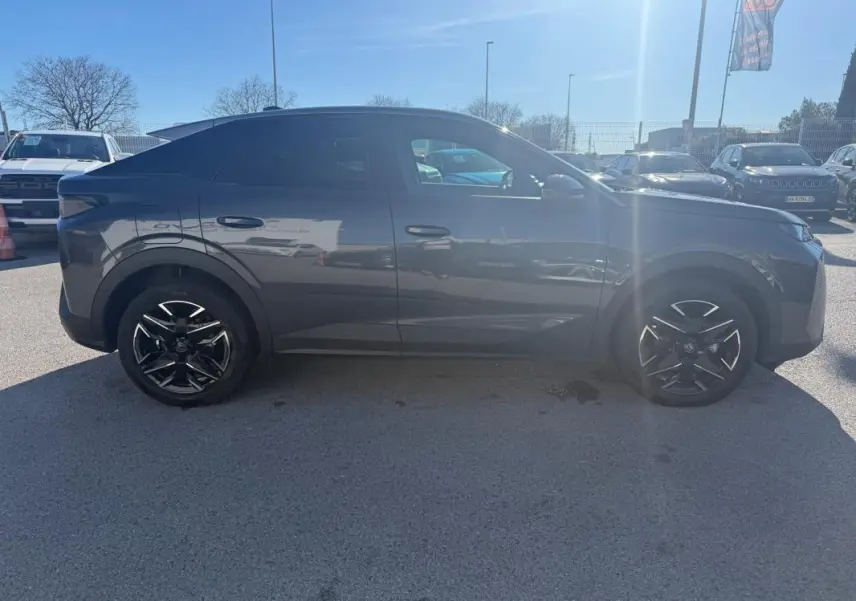 Peugeot 3008 Hybrid gris vue de profil côté gauche, avec jantes alliage noires 19 pouces sous un ciel ensoleillé.