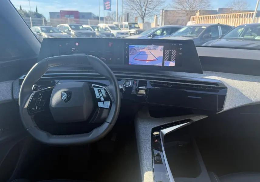 Vue intérieure du tableau de bord gris du Peugeot 3008 Hybrid 145 e-DCS6 Allure avec volant compact et écran numérique large.