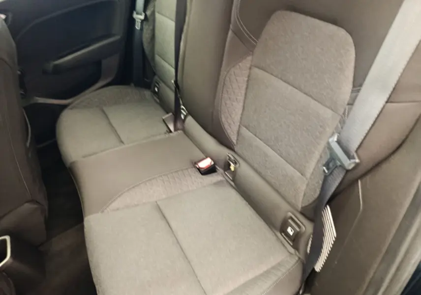 Vue rapprochée de la banquette arrière gris foncé de la Renault Clio Business E-TECH 140, avec ceinture de sécurité visible.