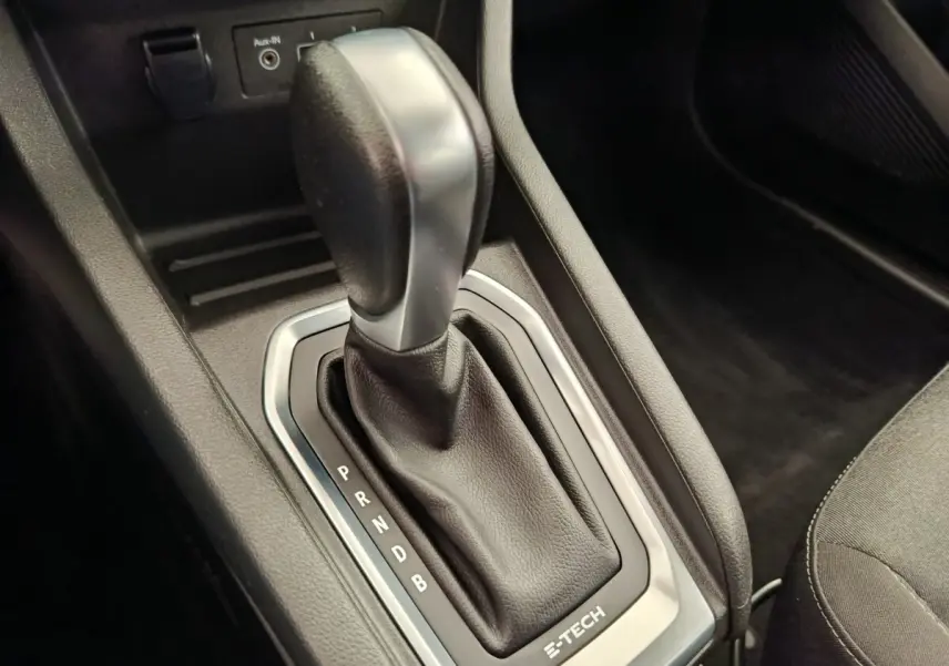 Gros plan sur le levier de vitesses automatique noir et argenté de la Renault Clio Business E-TECH 140, intérieur sombre.