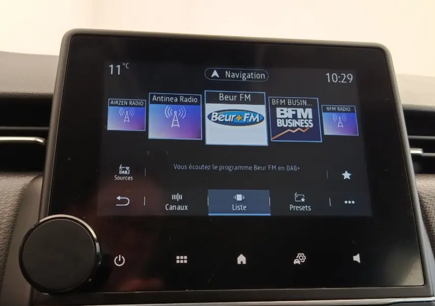 Écran tactile central de la Renault Clio Business E-TECH 140 affichant les stations radio numériques.