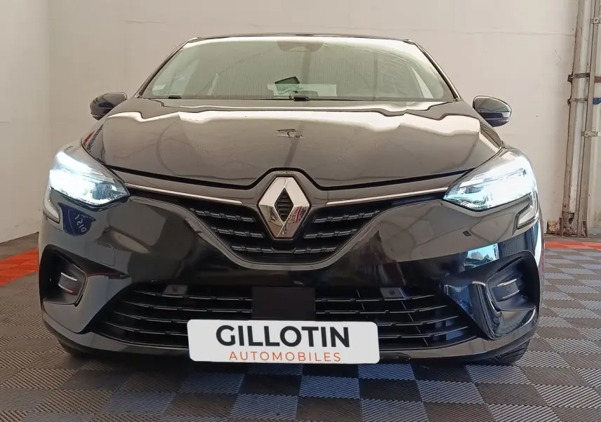 Vue frontale d'une Renault Clio Business E-TECH 140 noire avec phares LED allumés et calandre distinctive.