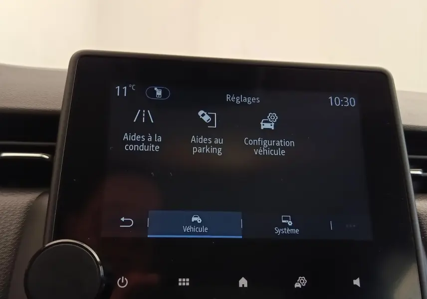 Écran tactile central de la Renault Clio Business E-TECH 140 affichant les réglages d’aides à la conduite et au parking.