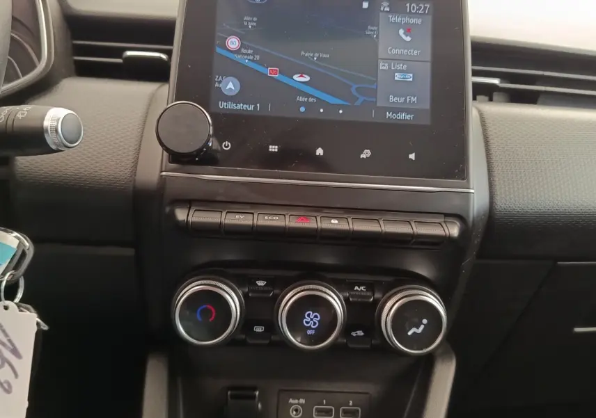 Vue rapprochée du tableau de bord central noir de la Renault Clio Business E-TECH 140 avec écran tactile et commandes de climatisation.