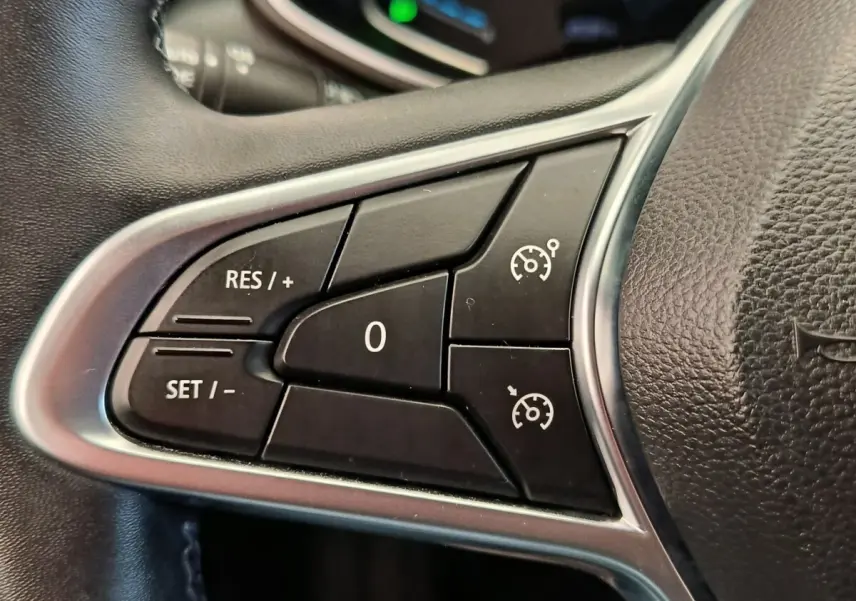 Gros plan sur les commandes de régulateur de vitesse au volant cuir noir de la Renault Clio Business E-TECH 140.