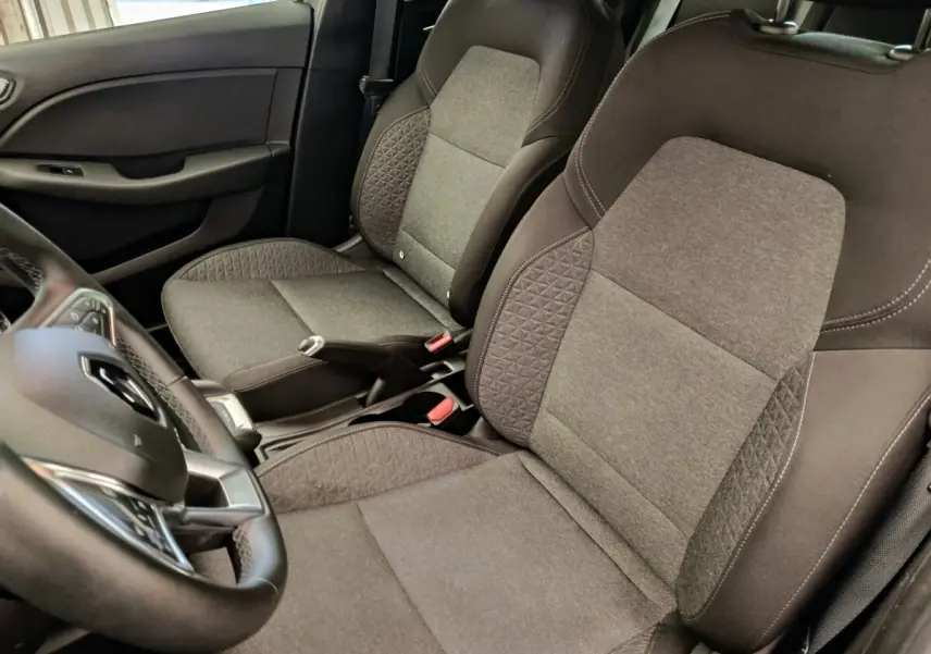 Vue intérieure rapprochée des sièges avant gris et noir de la Renault Clio Business E-TECH 140 avec volant cuir multifonctions.