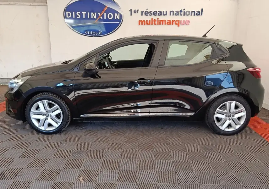 Profil côté gauche d'une Renault Clio Business E-TECH 140 noire, avec jantes alliage et vitres teintées, en intérieur showroom.