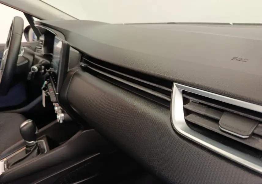 Vue intérieure côté passager du tableau de bord noir texturé de la Renault Clio Business E-TECH 140 avec aérateurs chromés.