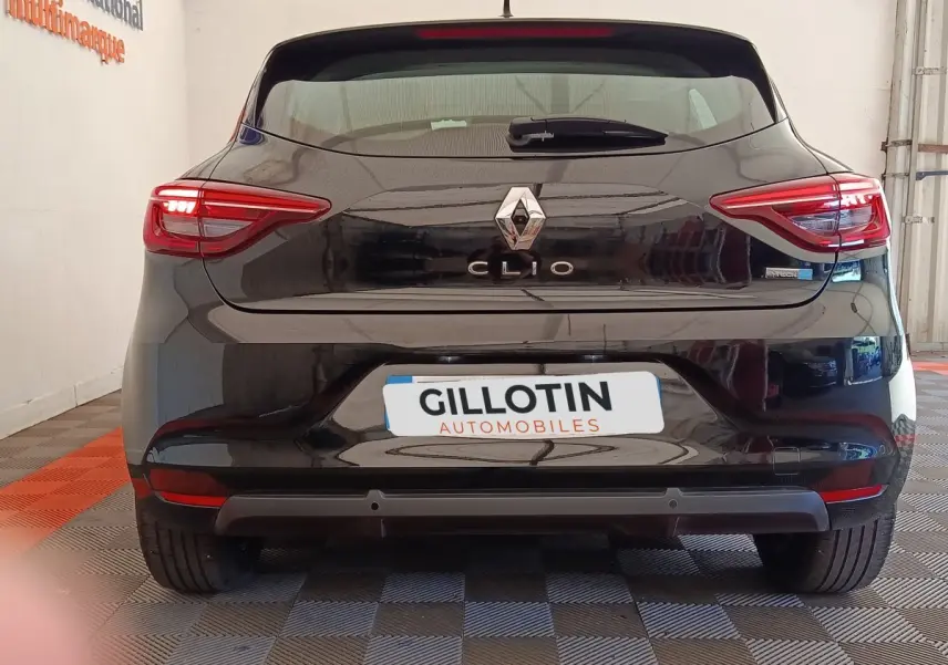 Vue arrière d'une Renault Clio noire avec feux LED allumés et logo Renault bien visible.