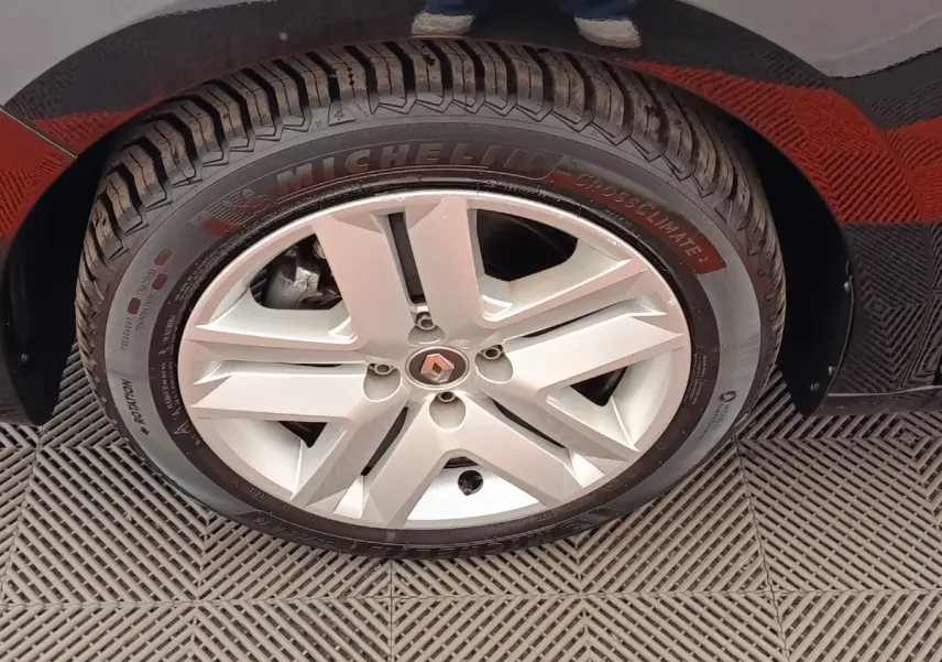 Gros plan sur la roue avant droite de la Renault Clio blanche, mettant en valeur la jante alliage et le pneu Michelin.