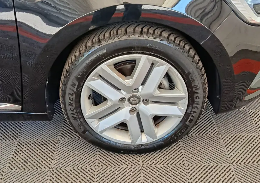 Gros plan sur la roue avant droite d’une Renault Clio noire, avec jante alliage et pneu Michelin visible.