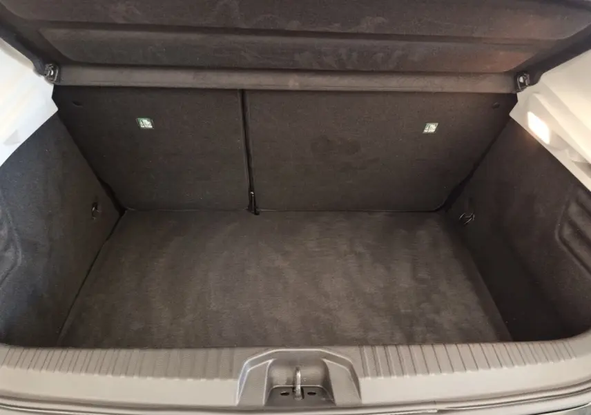 Coffre ouvert vu de dessus d’une Renault Clio Business E-TECH 140 blanche, intérieur noir et espace de rangement vide.