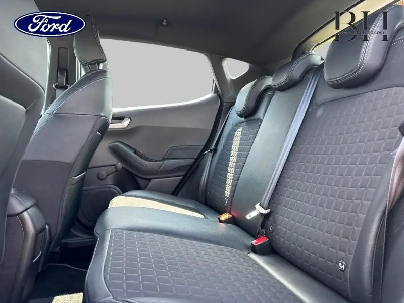 Vue intérieure côté droit des sièges arrière en cuir-tissu gris de la Ford Fiesta 2018, avec appuie-têtes et ceintures de sécurité.