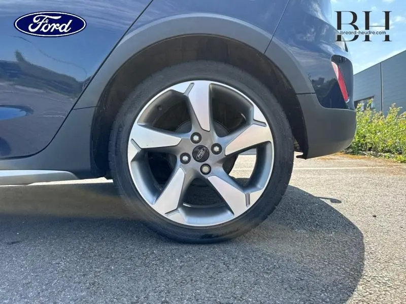 Gros plan sur la roue arrière droite avec jante alu de la Ford Fiesta Bleu Abysse, partie basse de la carrosserie visible.