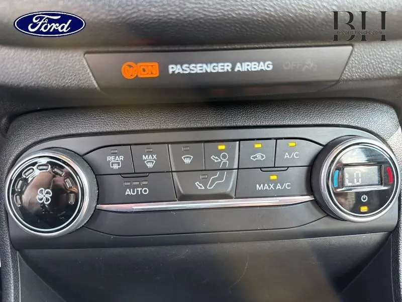 Vue rapprochée du tableau de bord de la Ford Fiesta 2018 Bleu Abysse, montrant les commandes de climatisation et l'indicateur airbag passager.