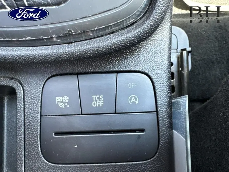 Gros plan sur les boutons de commande du système de traction et arrêt auto du moteur dans une Ford Fiesta Bleu Abysse 2018.