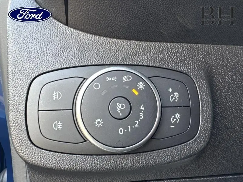 Gros plan sur la molette de réglage des phares dans l’habitacle d’une Ford Fiesta Bleu Abysse.