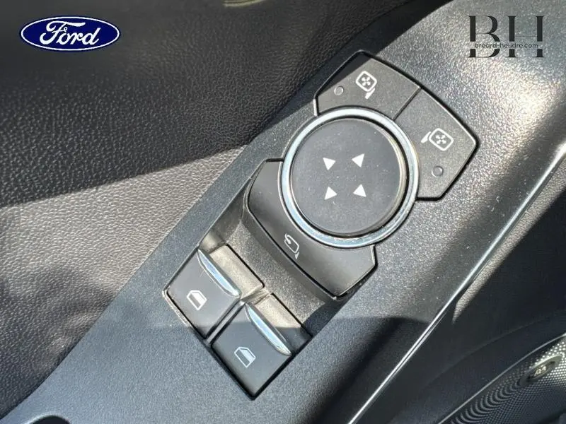 Gros plan sur les commandes de réglage des rétroviseurs et des vitres côté conducteur d'une Ford Fiesta 2018, intérieur noir.