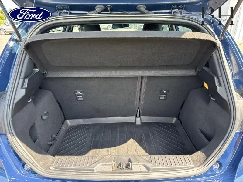 Coffre ouvert vu de l'arrière d'une Ford Fiesta 2018 bleu Abysse, montrant l'espace de chargement vide.