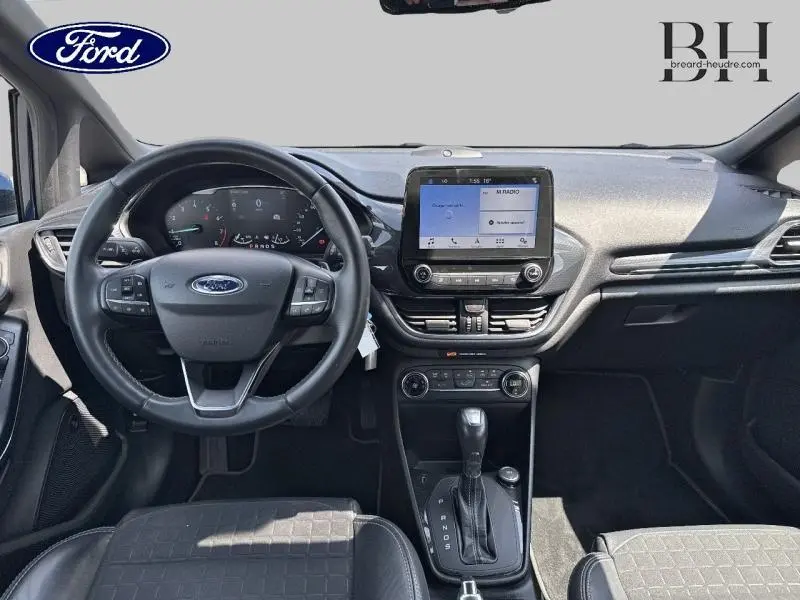 Vue intérieure avant de la Ford Fiesta 1.0 EcoBoost 2018 avec volant cuir, écran tactile et levier de boîte auto.