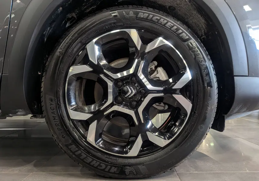Gros plan sur la roue arrière droite d'un Citroën C5 Aircross gris Platinium, mettant en valeur le pneu Michelin.