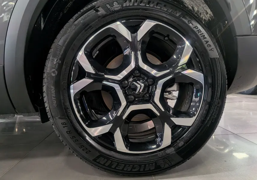 Gros plan sur la jante noire et argentée de 18 pouces avec logo Citroën, montée sur un pneu Michelin e-Primacy.