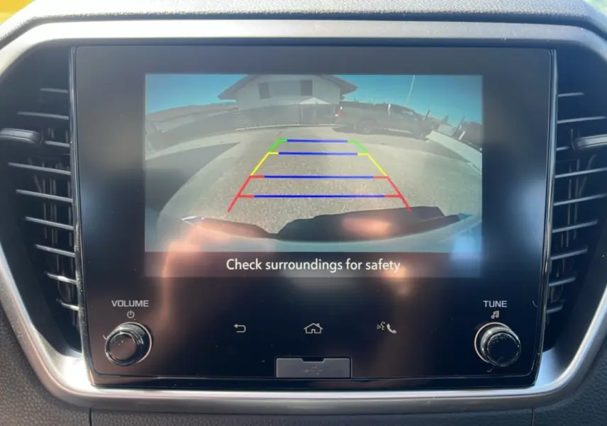 Écran tactile intérieur montrant la caméra de recul avec lignes de guidage colorées sur un Isuzu D-MAX blanc.