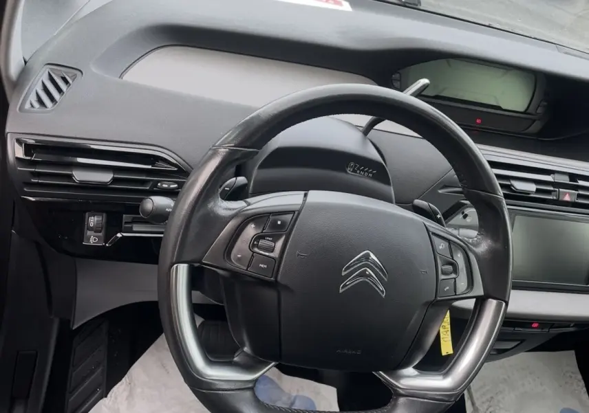 Vue avant d'une Citroën C4 Picasso marron 2017 avec pluie sur la carrosserie et plaques françaises visibles.