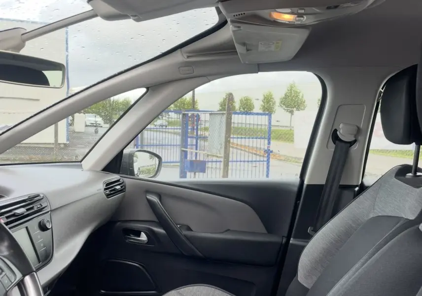 Vue intérieure centrée sur le volant cuir multifonction d'une Citroën C4 Picasso 2017, tableau de bord et écran tactile visibles.