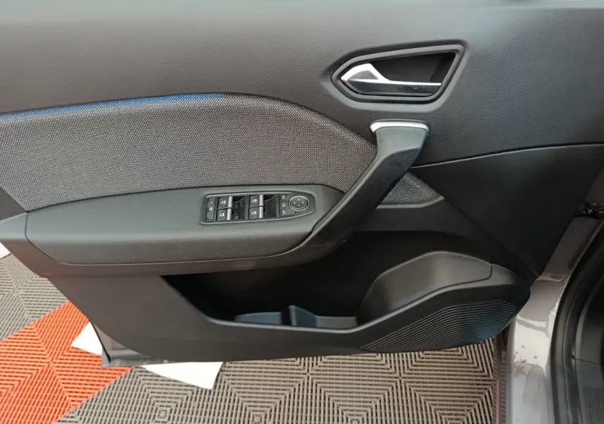 Porte côté gauche du Renault Captur 2025 gris foncé, avec commandes électriques des vitres et poignée intégrée.