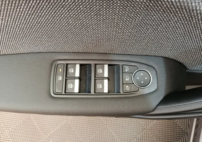 Panneau de commandes des vitres et rétroviseurs côté conducteur du Renault Captur gris foncé 2025.