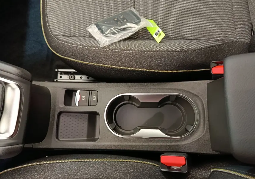 Vue plongeante sur la console centrale noire avec porte-gobelets et sièges gris foncé du Renault Captur 2025 Techno Eco-G.