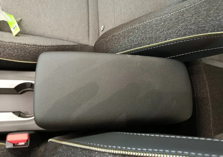Accoudoir central noir avec surpiqûres jaunes entre les sièges avant du Renault Captur Techno Eco-G 2025.