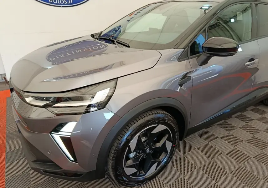 Vue 3/4 avant droit d'un Renault Captur gris foncé avec phares LED et jantes noires au design moderne.