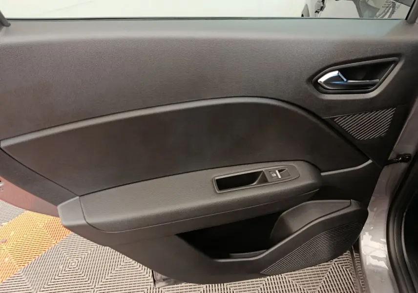 Porte intérieure côté gauche noire du Renault Captur 2025, avec poignée et commande de vitre électrique.