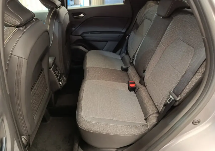 Vue latérale intérieure côté droit des sièges arrière gris du Renault Captur Techno Eco-G 2025 avec ceinture et appuie-tête.