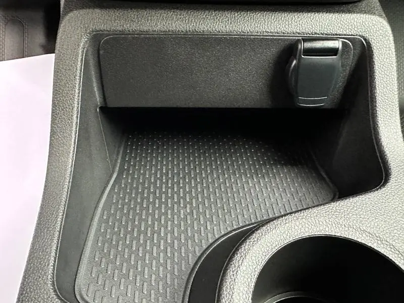 Rangement central noir avec prise 12V visible dans l'habitacle du Nissan Townstar électrique 2024.