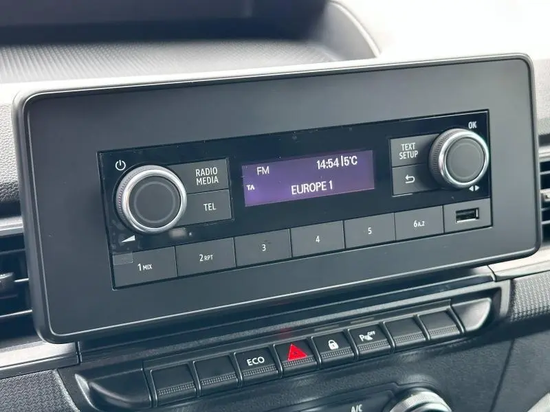 Écran multifonction noir du poste radio du Nissan Townstar gris 2024, affichant la station Europe 1 en FM.