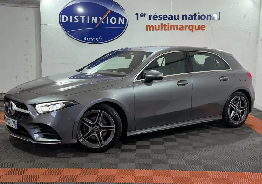 Mercedes Classe A 200 AMG Line gris foncé vue de profil côté gauche dans un showroom avec logo Distinxion en arrière-plan.