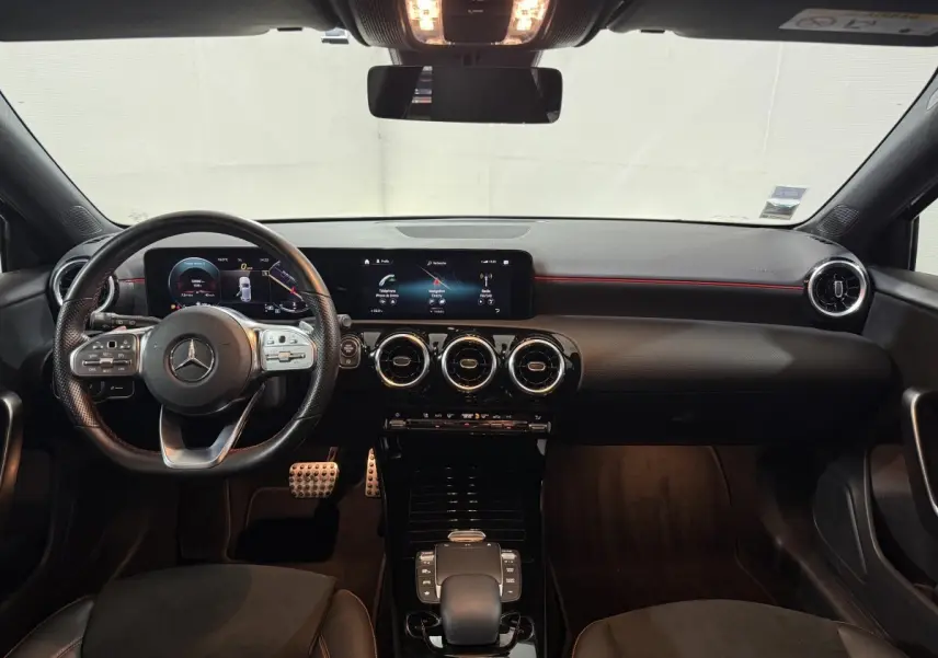 Vue intérieure frontale du tableau de bord noir et volant cuir de la Mercedes Classe A 200 AMG Line 2021.