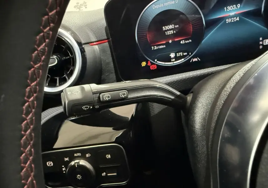 Gros plan sur le tableau de bord numérique et la commande des essuie-glaces de la Mercedes Classe A gris foncé, version AMG Line.