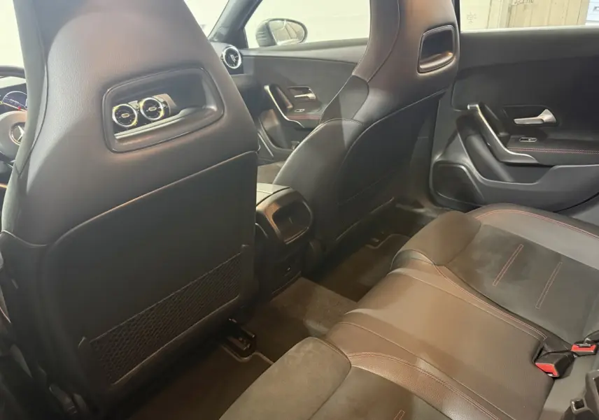 Vue intérieure arrière côté droit de la Mercedes Classe A 200 AMG Line 2021 avec sièges cuir noir et surpiqûres rouges.