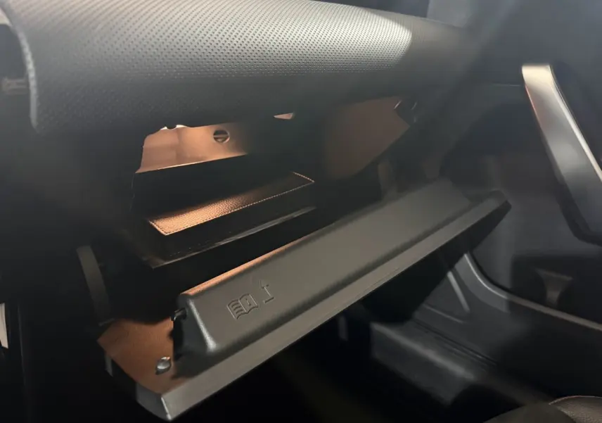 Vue rapprochée de la boîte à gants ouverte côté passager du Mercedes Classe A A 200 AMG Line gris foncé, intérieur noir.